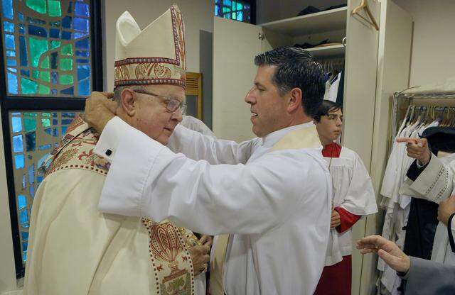 The Rev. Alberto Cutié, right, arranges the vestments of Bishop Leo Frade, left, the Episcopal bishop of Southeast Florida, on May 13, 2025, when Father Cutié became the new rector of St. Benedict’s Episcopal Church in Plantation. 